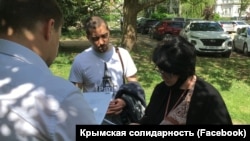 Співробітник російської прокуратури вручає застереження адвокату Еміне Авамілєвій