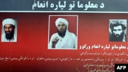 A billboard with photos of Osama bin Laden (left), Adam Gadhan (center), and Mullah Mohammad Omar, posted in a Kabul park, asks for information regarding the whereabouts of the Al-Qaeda fugitives.