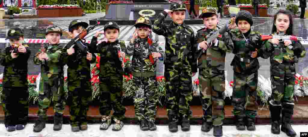 Wearing army-style camouflage costumes, Azerbaijani children take part in a ceremony to mark the 21st anniversary of what Azerbaijan refers to as the Khojaly Massacre at a monument to victims in Baku. Azerbaijani authorities say 613 people died when Armenian troops attacked the village of Khojaly in Nagorno-Karabakh in 1992 in what Baku has described as &quot;genocide,&quot; a term fiercely rejected by Yerevan. (AFP/Tofik Babayev)