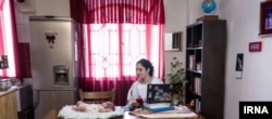 In this now-deleted IRNA photo, Iranian writer Sara Kan'ani is seen glancing at Ahu, a foster child she cared for for 40 days.