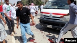 People gather at the site of the bomb attacks in Baquba.