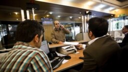 An Iranian customer speaks with a bank clerk at the Export Development Bank of Iran in the capital Tehran on July 27, 2015. AFP PHOTO / BEHROUZ MEHRI 