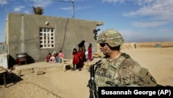 U.S. Army soldiers speak to families in rural Anbar on a reconnaissance patrol near a coalition outpost in western Iraq.