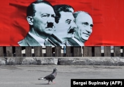 Плакат із зображенням Адольфа Гітлера, Йосипа Сталіна і президента Росії Володимира Путіна в Києві, 28 липня 2014 року
