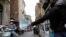Un bărbat vinde măști de protecție pe o stradă din Catania, Italia