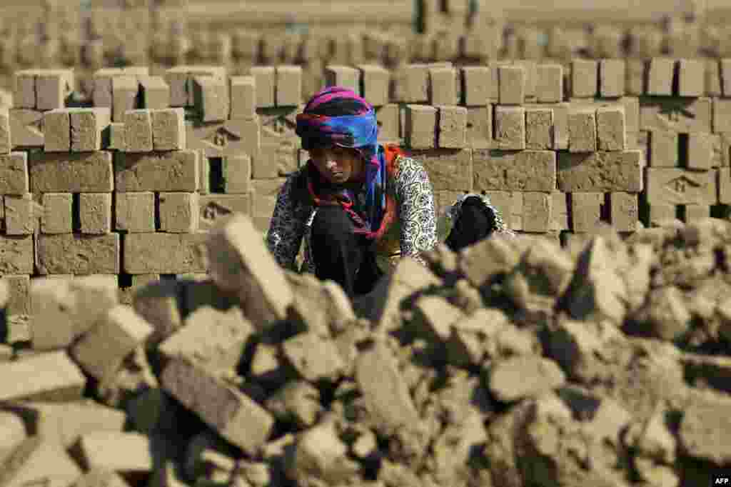 A female Pakistani laborer makes bricks at a factory on the outskirts of Lahore. (AFP/Arif Ali)