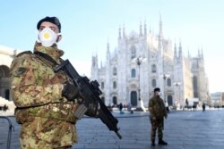 Мілан, Італія, 24 лютого 2020 року: закритий через спалах хвороби Міланський собор і військові патрулі в масках