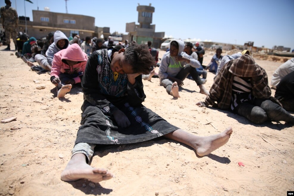Emigrantët ulen pasi ata u shpëtuan nga mbytja në det të hapur, në Tripoli, Libi, më 16 maj.