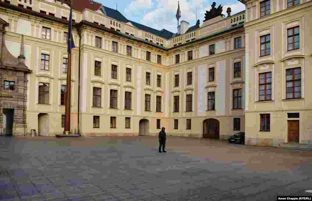 Un gardian fotografiat în fața curții pustii a castelului din Praga.&nbsp;