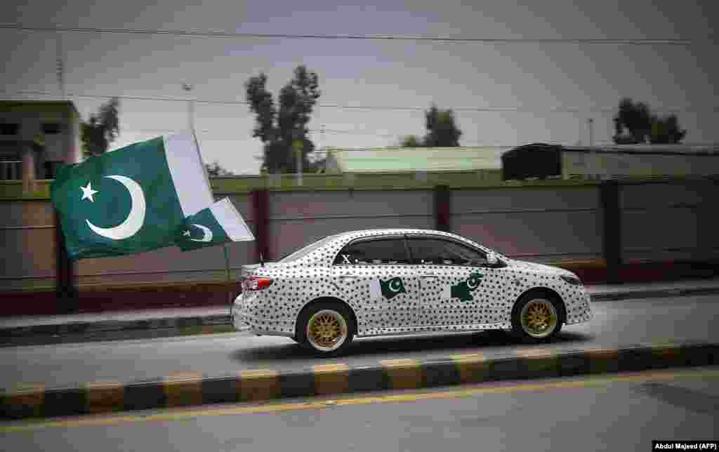 A Pakistani resident drives his car decorated with national flags to mark the country's Independence Day in Peshawar on August 14. (AFP/Abdul Majeed)