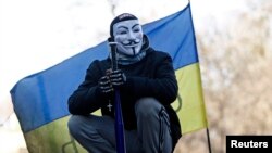 A Ukrainian antigovernment protester stands atop barricades in the center of Kyiv.