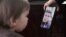 Ihar Losik's wife, Darya Losik, shows a photo of him to their young daughter in January 2023.