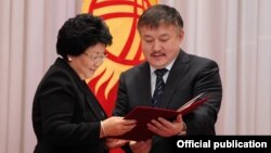 Akmatbek Keldibekov (right), then the parliament speaker, consults with then-Kyrgyz President Roza Otunbaeva in November 2011.