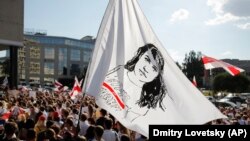 Protestçiler 17-nji awgustda Minskde geçirilen ýörişde oppozisiýa syýasatçysy Swýatlana Tsihanouskaýanyň portreti ýerleşdirilen baýdagy galgatdylar.