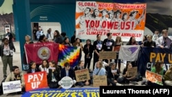 Activists hold a silent protest inside the venue for the COP29 UN climate change conference to demand that rich nations provide climate finance to developing countries. 