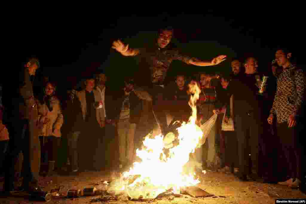 An Iranian man jumps over a bonfire during a celebration, known as &quot;Chaharshanbe Souri,&quot; or Wednesday Feast. This celebration marks the eve of the last Wednesday of he solar Persian year, Tuesday, March,19,2019 in Tehran, Iran. &nbsp;