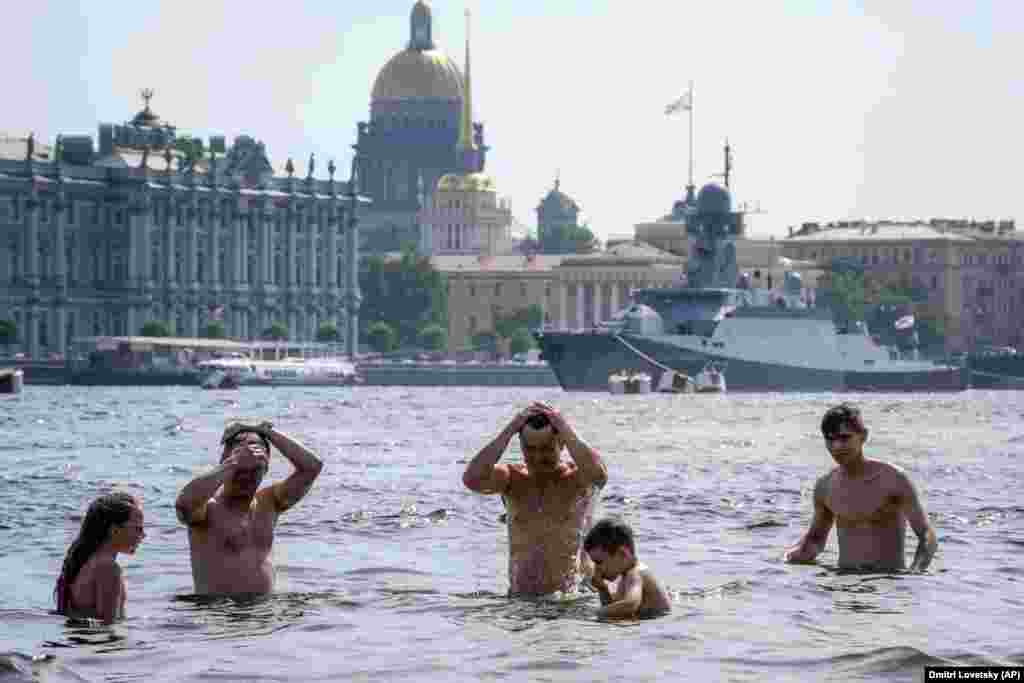 Люди купаются в Неве в Санкт-Петербурге, Россия, 14 июля