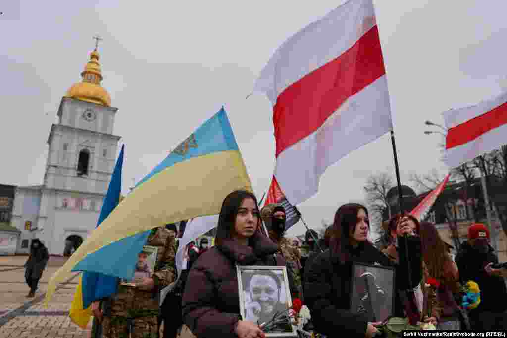 Люди вшановували пам&#39;ять загиблих за Україну білорусів, тримаючи в руках їхні портрети, прапори України та біло-червоно-білі стяги (історичний прапор Білорусі)