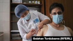 Бішкектегі медицина орталығында Қытайдың Sinopharm вакцинасын алып отырған адам. 19 мамыр 2021 жыл.