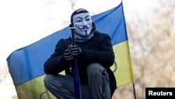 A Ukrainian antigovernment protester stands atop barricades in the center of Kyiv.