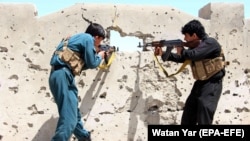 FILE: Members of the Afghan security forces take position during an operation against Taliban in Helmand province in April 2017.