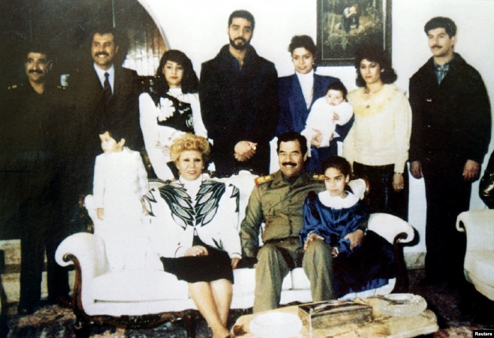 در تصویر همراه اعضای خانواده&zwnj;اش: دخترانش، رغد، رنا و پسرانش، عدی و قصی. در پایین حلا، صدام حسین و ساجده طلفاح. پایان دهه ۱۹۸۰.