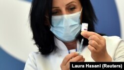 Një punëtore shëndetësore duke u bërë gati të admnistrojë një dozë të vaksinës kundër koronavirusit. Prishtinë, 29 mars 2021. 