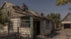 A man an his wife repair the roof of their damaged house after recent shelling in a village in Ukraine's eastern Donetsk region on October 5. 