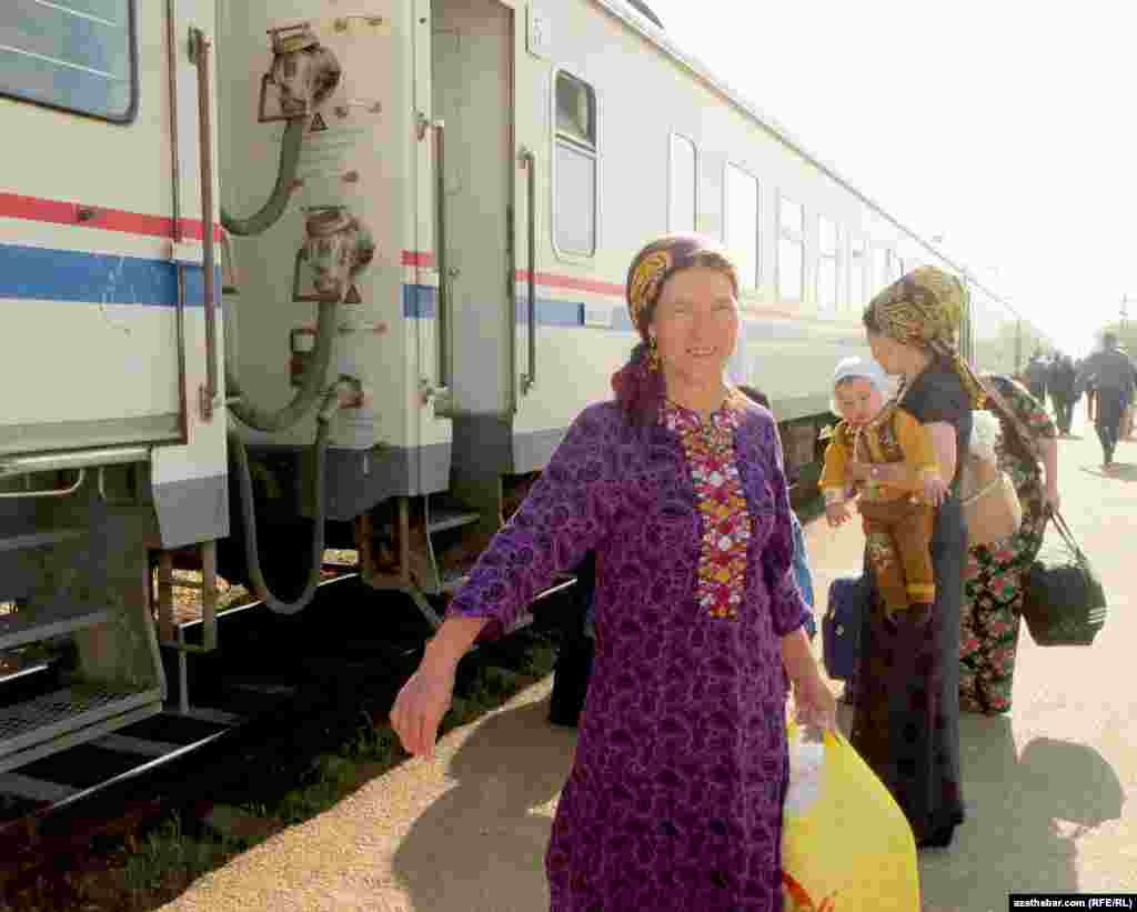 Ahal welaýatynyň Änew stansiýasynda otludan düşüp barýan ýolagçylar.