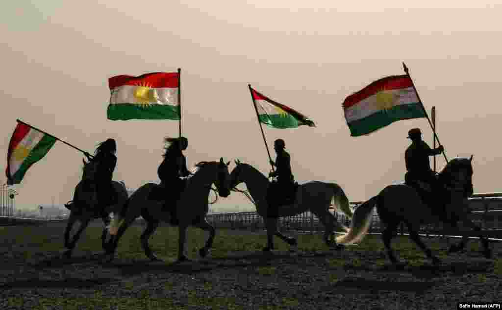 Iraqi Kurdish horsemen ride carrying Kurdish flags celebrating their flag day in the northern city of Irbil on December 17. (AFP/Safin Hamed)