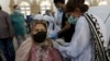 A woman receives a shot of the Sinopharm coronavirus vaccine from a health worker at a vaccination center in Karachi earlier this month. 