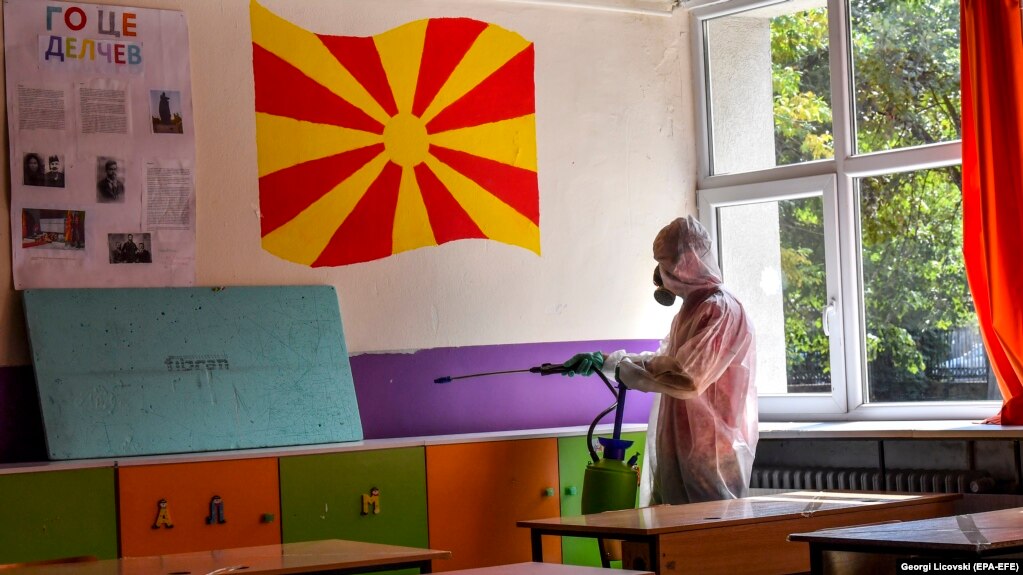 Një punëtor dezinfekton një klasë në një shkollë fillore. Shkup, shtator 2020.