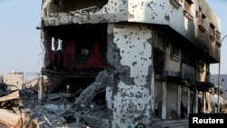 Remains of cars and buildings are seen in the town of Awamiya, August 9, 2017