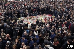People hold a minute of silence around a makeshift memorial at Place de la Bourse in Brussels on March 23.