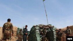 FILE: Afghan soldiers take positions at a check post in the restive southern Helmand province.