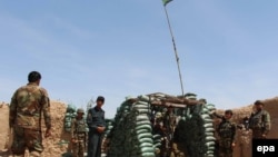 FILE: Afghan soldiers take positions at a check post in the restive southern Helmand province.