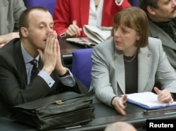 Angela Merkel duke biseduar me Friedrich Merz, atëherë anëtar i parlamentit gjatë një sesioni të Parlamentit gjerman në Reichstag të Berlinit, më 17 shkurt 2000.