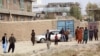 Residents gather near the site of a suicide attack on prison employees' vehicle in Kabul on October 31.