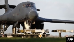 Ground personnel load Joint Direct Attack Munitions (JDAM) into a US Air Force B-1 bomber at RAF Fairford in southwest England -- one of three bases Britain has allowed US forces to use for "certain defensive operations."