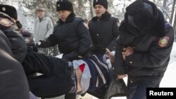 Полицейлер қарсылық акциясына қатысқан адамды әкетіп барады. Алматы, 25 ақпан 2012 жыл.