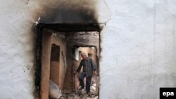 An ethnic Uzbek man walks through the ruins of his house, which was destroyed during ethnic clashes in Osh, on June 17.