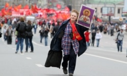 Прихильниця російської комуністичної партії несе ікону радянського диктатора Йосипа Сталіна під час демонстрації з нагоди Дня праці в Москві, 01 травня 2012 року