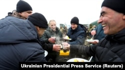 Ukrainian citizens celebrate after they were exchanged during a prisoner swap between Ukraine and Russia-backed separatists near the Mayorske crossing point in the eastern Donetsk region.