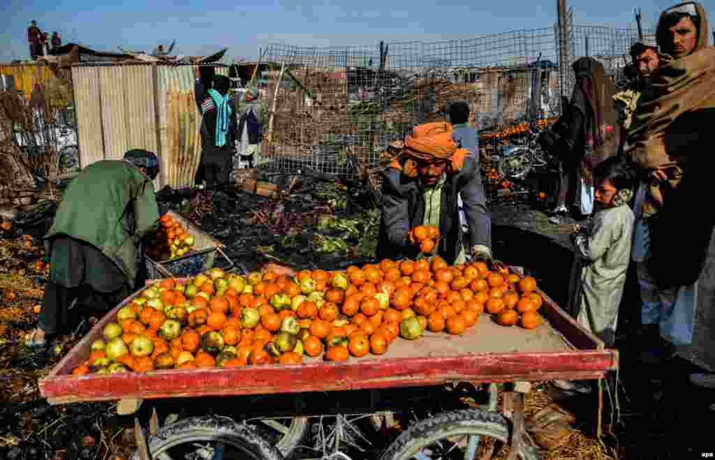 Traders salvage what&#39;s left of their stock on February 15 after dozens of shops caught fire at a market in Chaman, Pakistan. (epa/Akhter Gulfam)