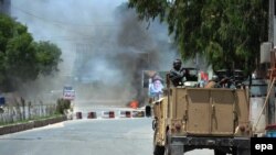 Smoke billows from the scene where suspected militants attacked the state-run RTA TV station in Jalalabad on May 17.