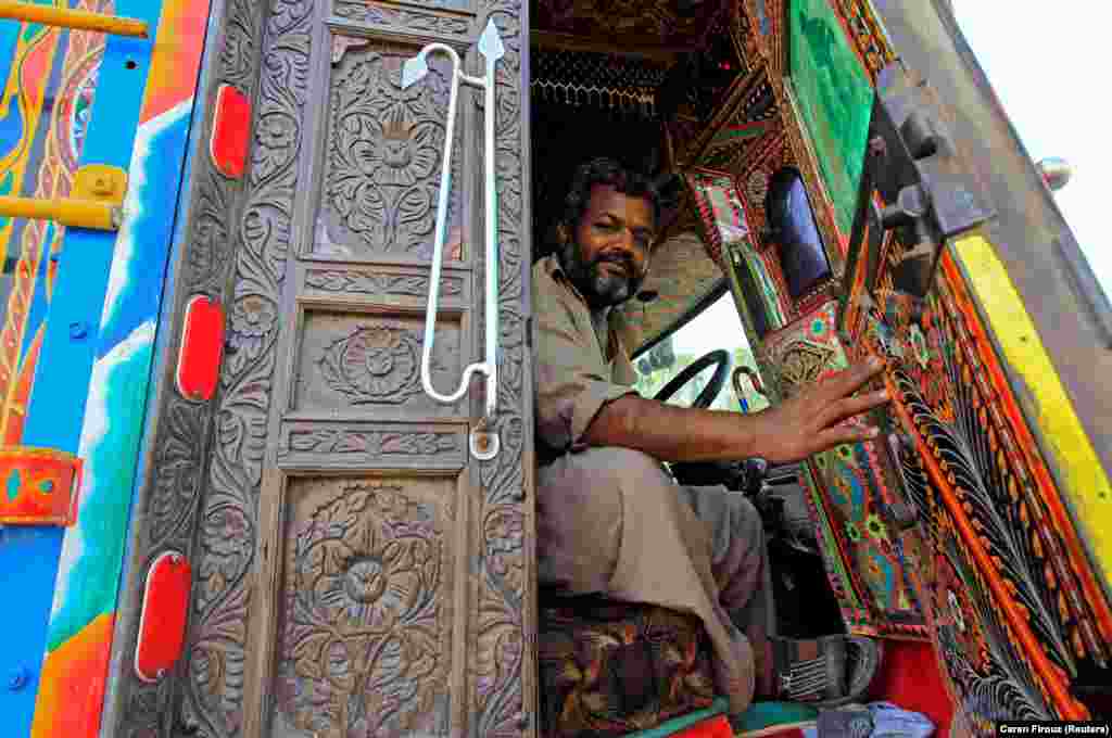 A driver in Faisalabad shows off the luridly decorated cab of his truck. As well as being a means to show off a driver's "personality," truck decorations have one basis in business logic. 