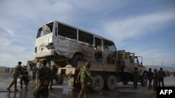 FILE: Afghan National Army (ANA) soldiers stand near a bus damaged by a suicide attack close to the provincial capital Mazar-e Sharif in February 2016.