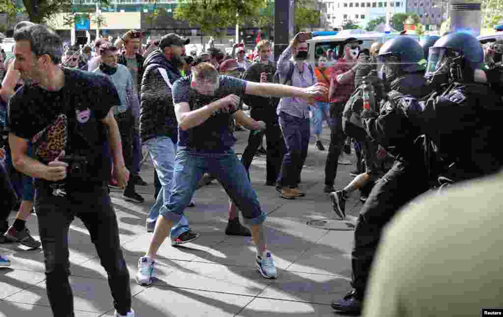 Police officers pepper spray protesters during a demonstration against coronavirus lockdown measures at Alexanderplatz in Berlin on May 9. (Reuters/Christian Mang)