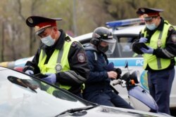 Жолда жүргізушілердің құжатын тексеріп тұрған полиция қызметкерлері. Алматы, 14 сәуір 2020 жыл.