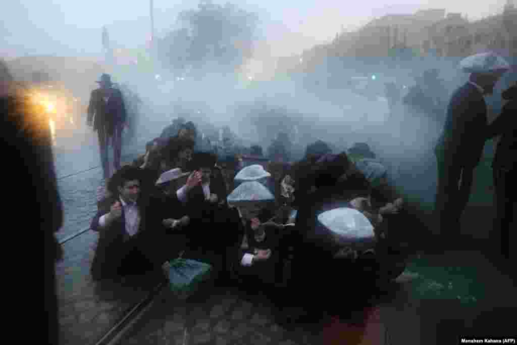 Israeli security forces spray water as they try to disperse ultra-Orthodox Jews from blocking the road in a demonstration against conscription in Jerusalem on November 26. (AFP/Menahem Kahana)